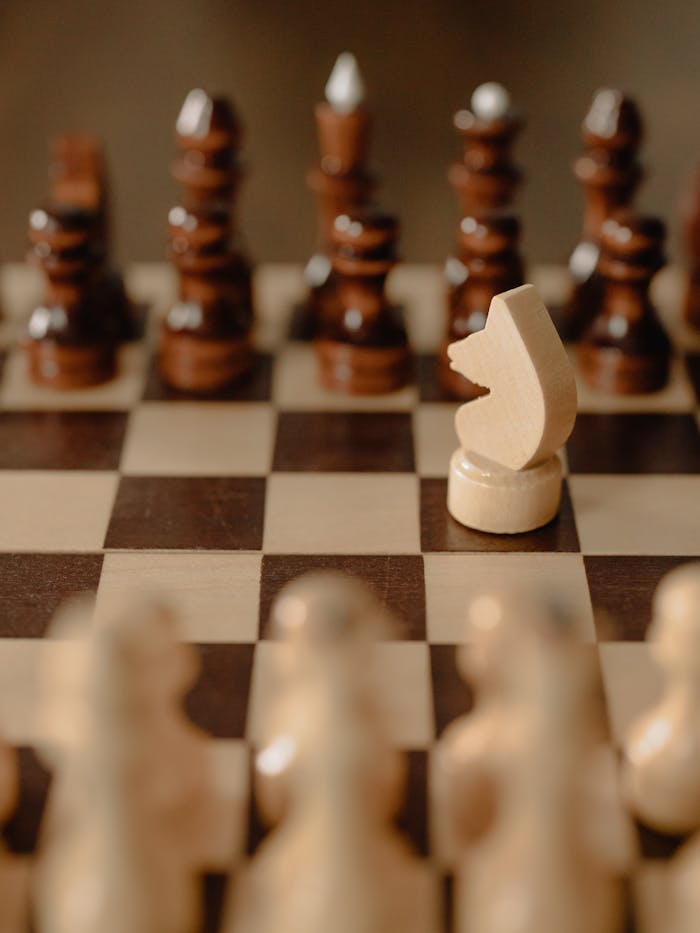 Close-up of a chessboard with a strategic knight piece in focus, symbolizing tactics and strategy.